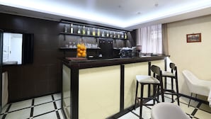 A bar area with a counter, chairs, and a television. - Hotel Oberig Kiev (Kyiv)