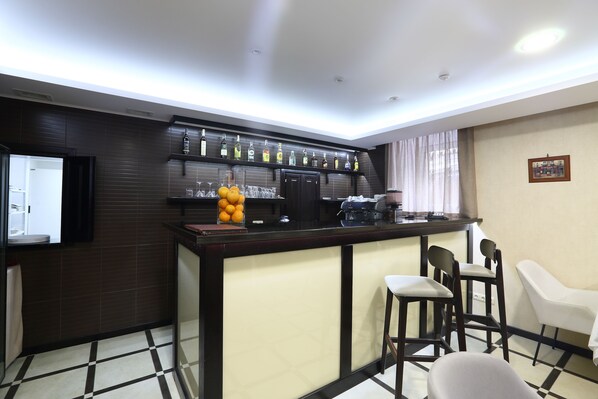 Una zona de bar con mostrador, sillas y televisor.