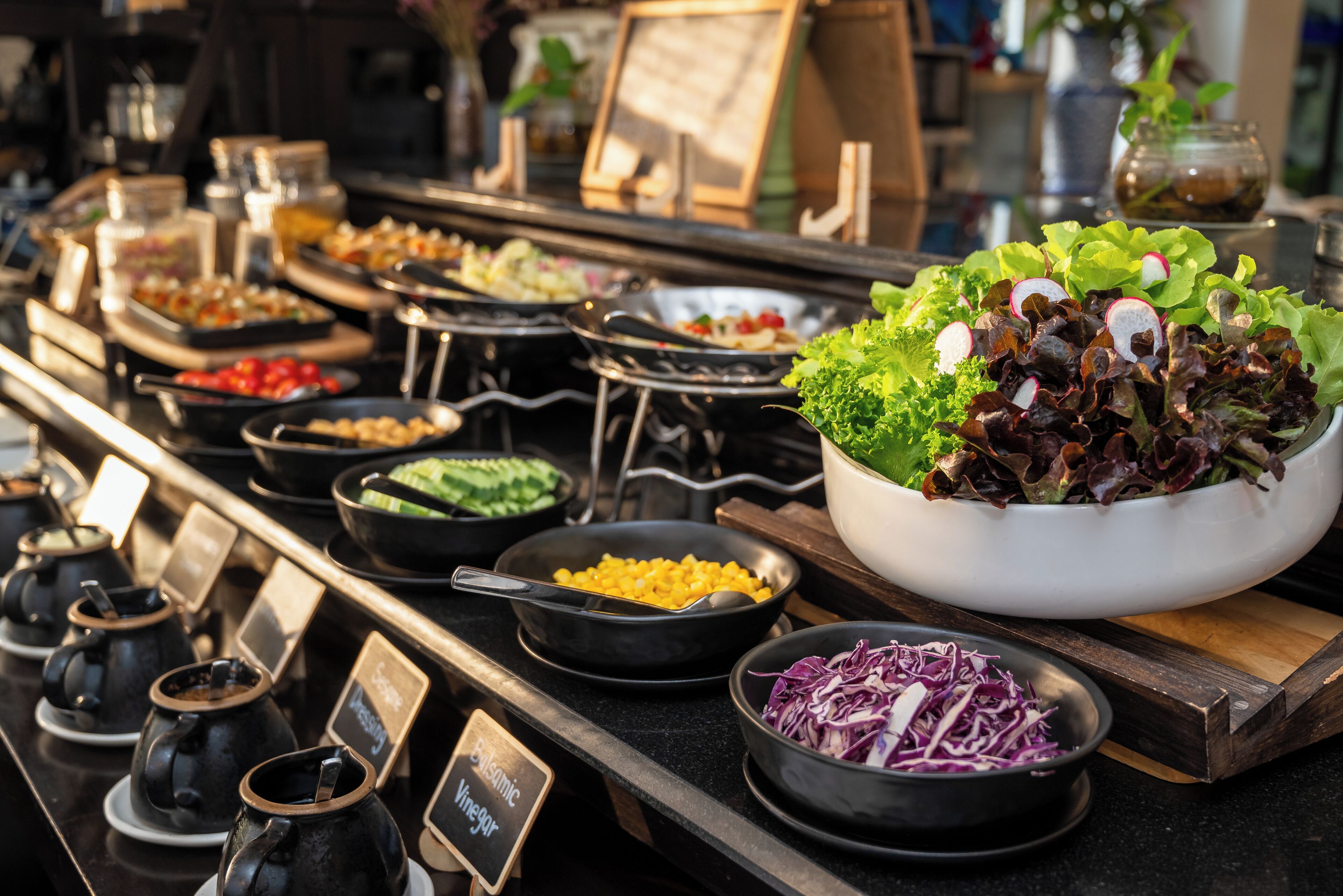 Een buffet met diverse gerechten, waaronder salades en dipsauzen.