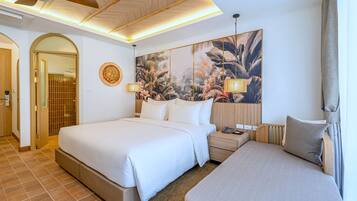 A hotel room with a large bed, a smaller bed, a nightstand, a wall-mounted lamp, and a large floral artwork.