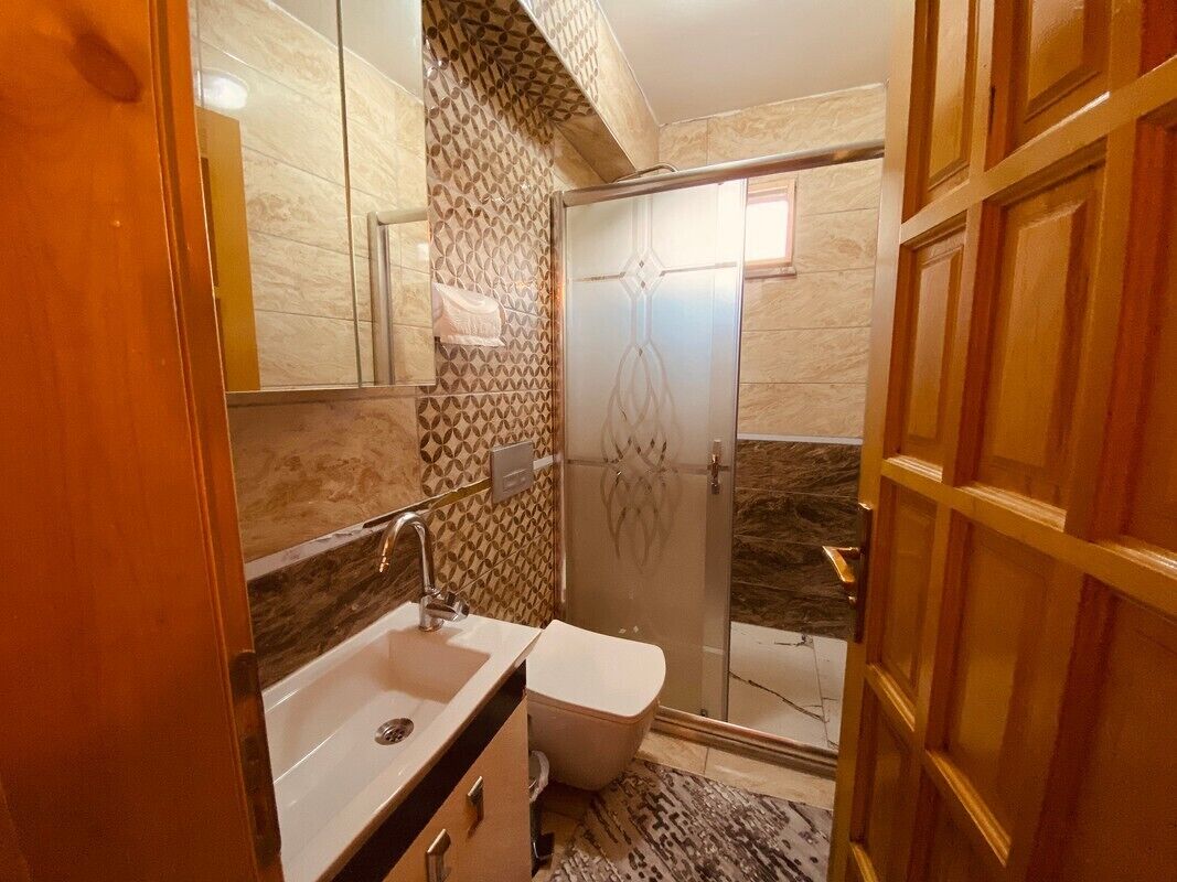 A bathroom with a sink, toilet, and shower.