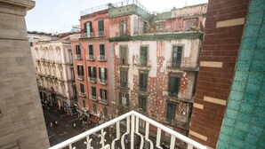 A view from a balcony overlooking a street with multi-story buildings, some with balconies and visible wear. - The Boutique Napoli Suite (Naples)