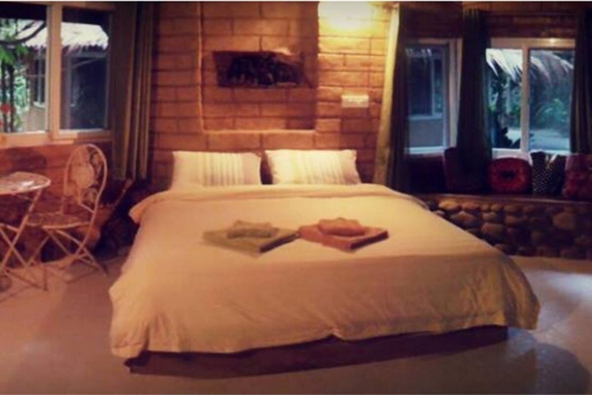 Une chambre confortable avec un grand lit, une petite table et une chaise.