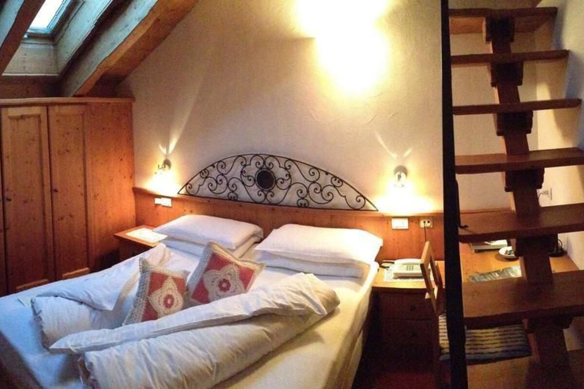 Ein Schlafzimmer mit einem Bett, einem Holzschrank und einem Oberlicht.