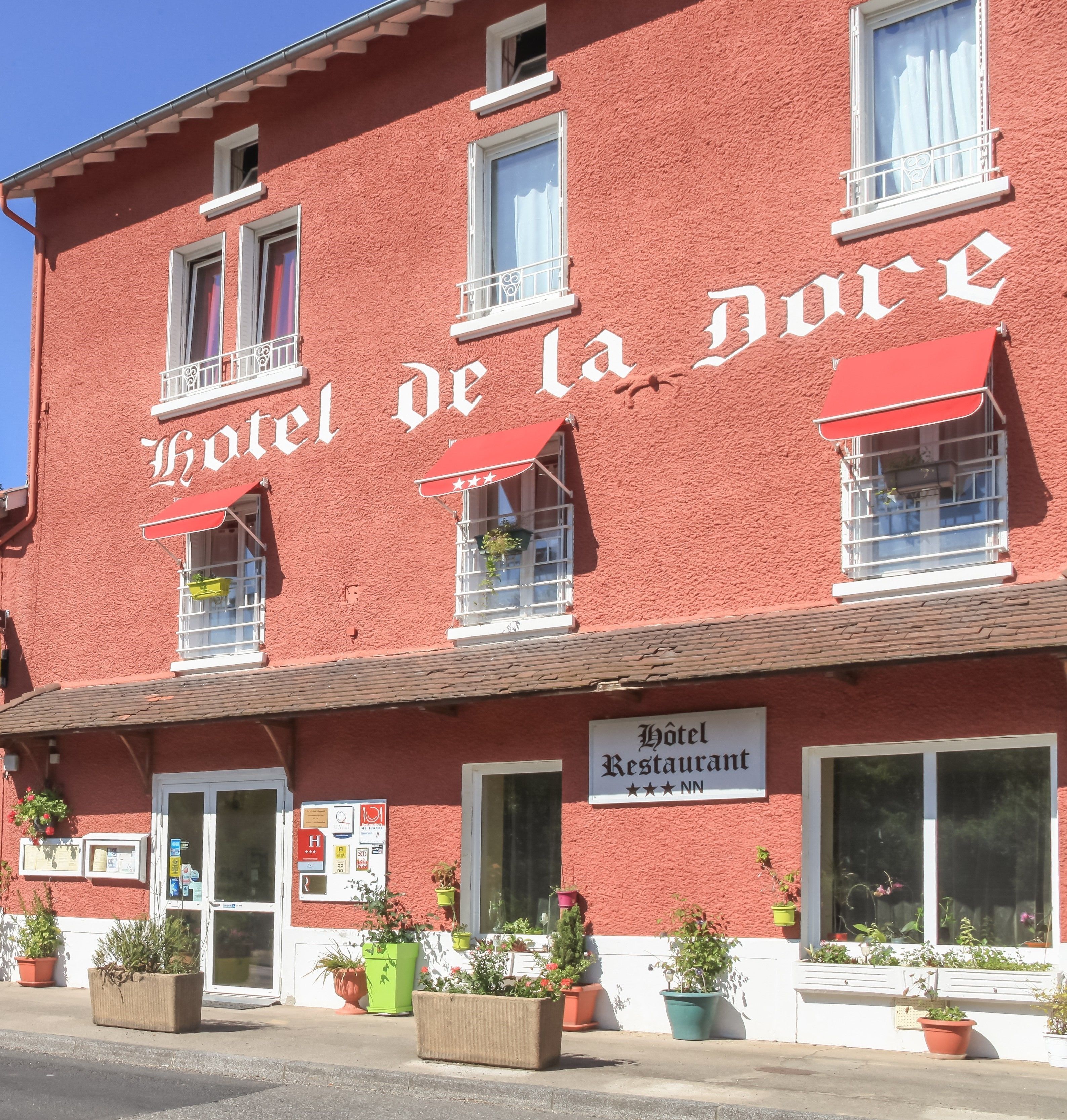 Un bâtiment rouge sur lequel on peut lire l’inscription : « Hôtel de la Dune ».