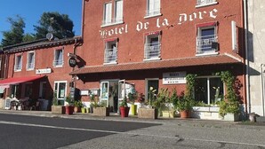 A red brick building with a sign reading 'Hotel de la Loire' and a restaurant sign below it. - Hotel Restaurant De La Dore (Vertolaye)