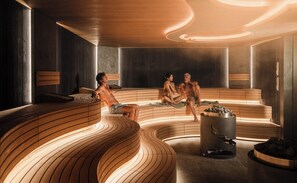 Eine Sauna mit Holzbänken und einer zentralen Heizquelle.