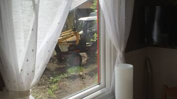 Una ventana con cortinas blancas, un control remoto y un juguete colorido en el alféizar.