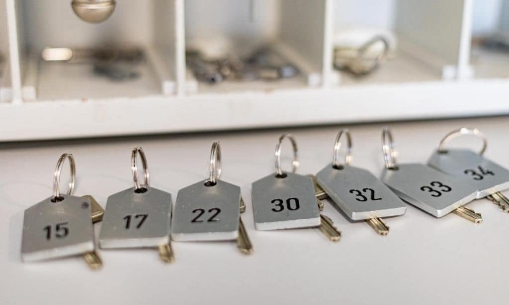 Una hilera de llaves numeradas sobre una superficie blanca, probablemente para el acceso a habitaciones de hotel.