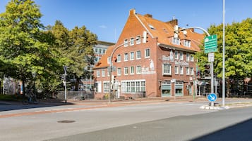 A historic building with a red brick facade, multiple windows, and a sign indicating it is a hotel.