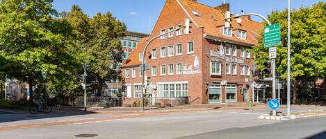A historic building with a red brick facade, multiple windows, and a sign indicating it is a hotel.