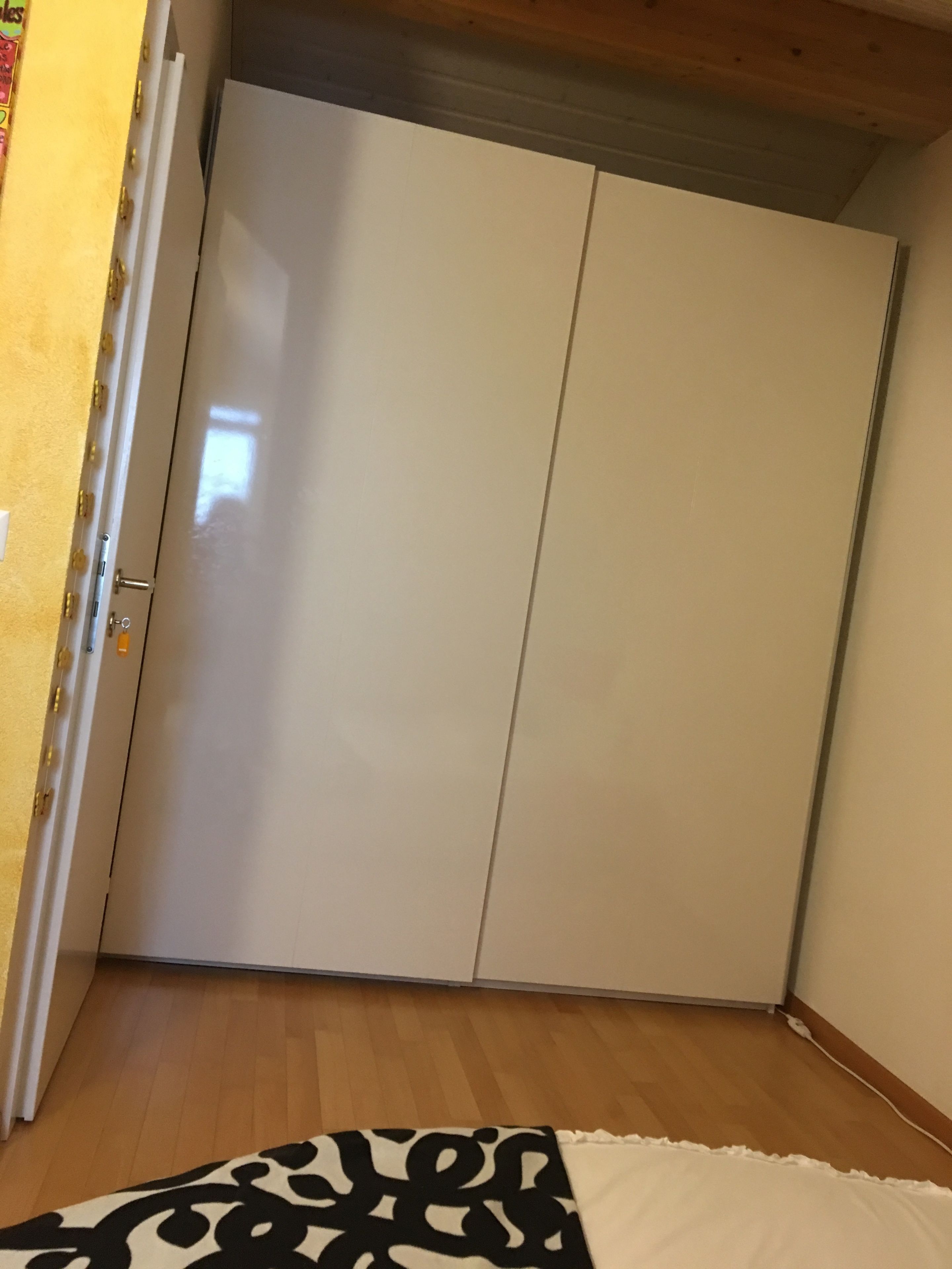 Une pièce dotée d’une armoire, d’un tapis à motifs et d’un plancher en bois.