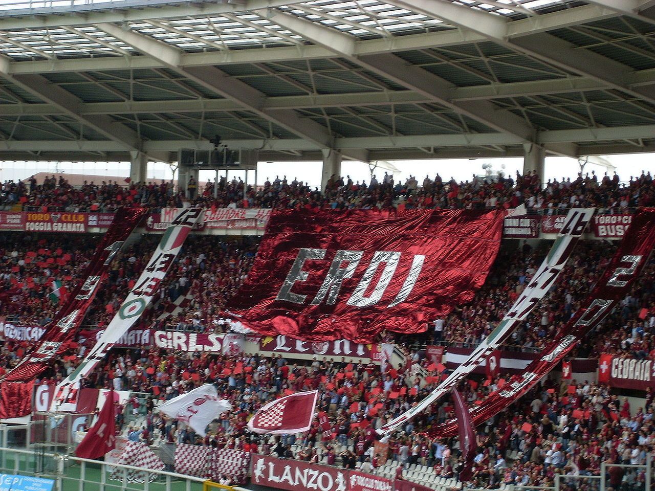 A stadium filled with spectators, some holding flags and banners.