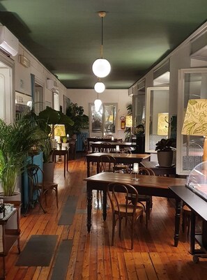 A restaurant with wooden tables and chairs, potted plants, and hanging pendant lights. - Albergo Ristorante San Giors (Turin)