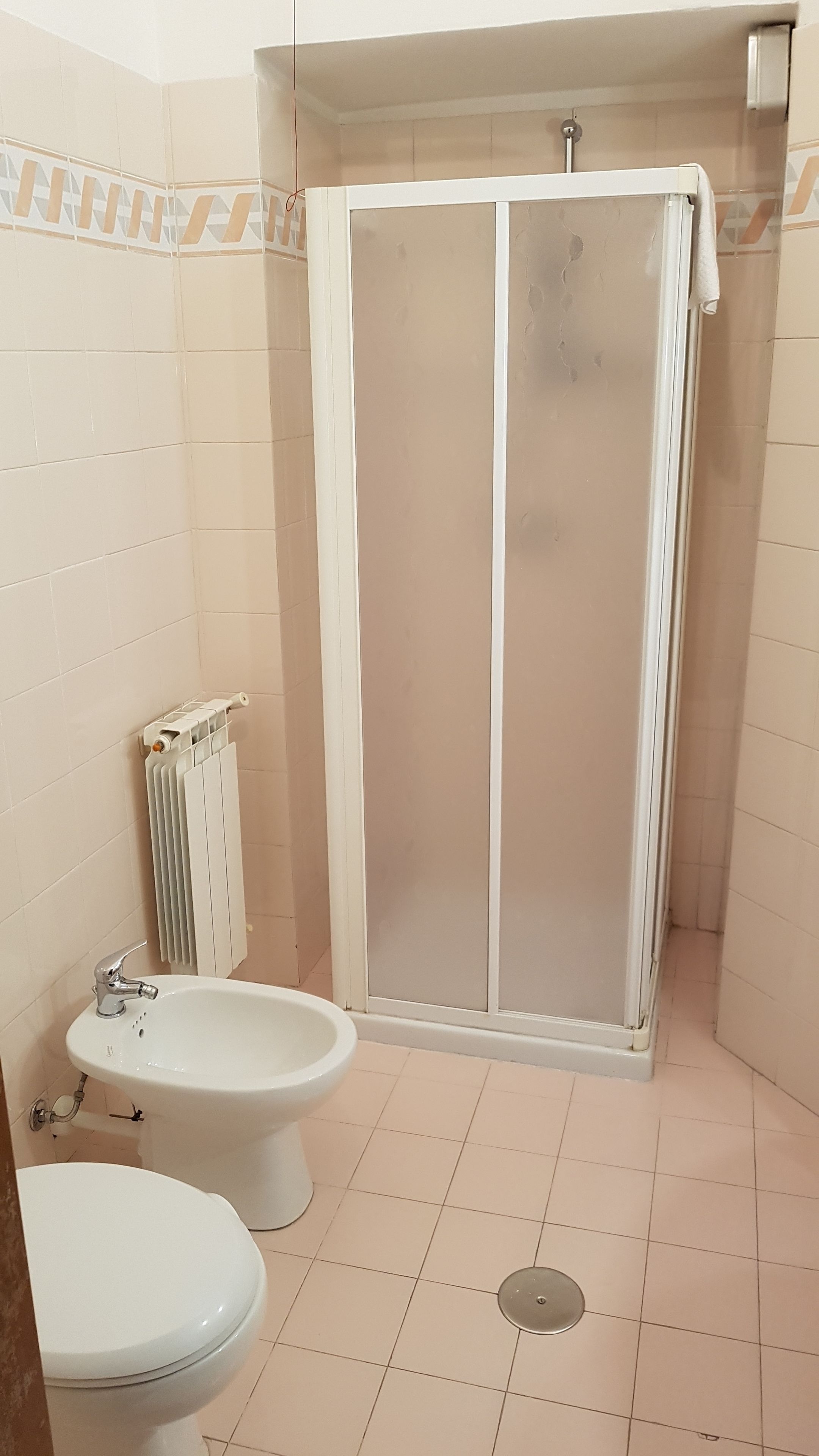 Un baño con cabina de ducha, inodoro y bidé.