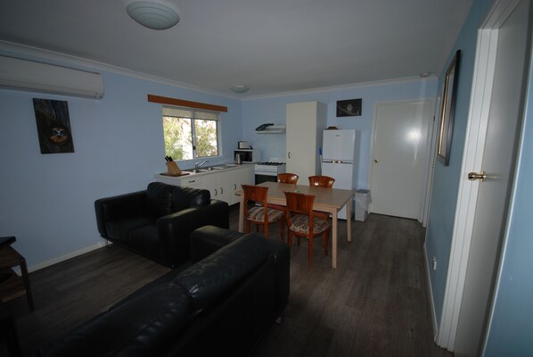 A compact living space with a kitchenette, a dining area, and a seating area.