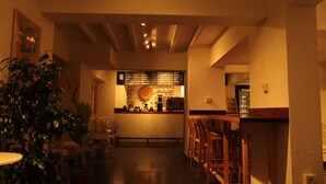 Un restaurante con mostrador, sillas y una pizarra de menú.