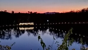 Vista noturna de um lago com um letreiro de neon que diz 'NAN GREEN LAKE VIEW'.