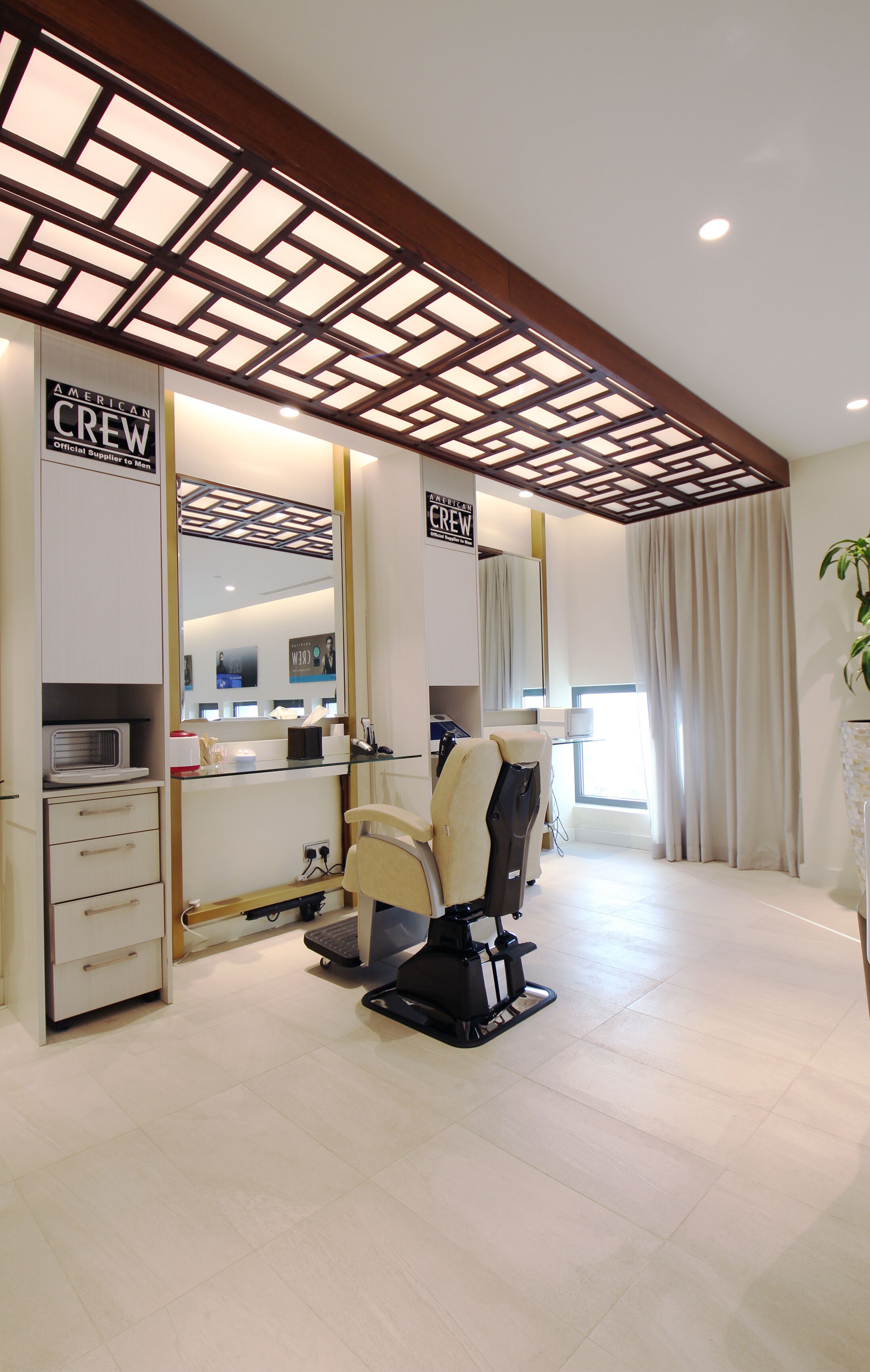 A modern hair salon with a large mirror, a hair washing station, and a comfortable chair.