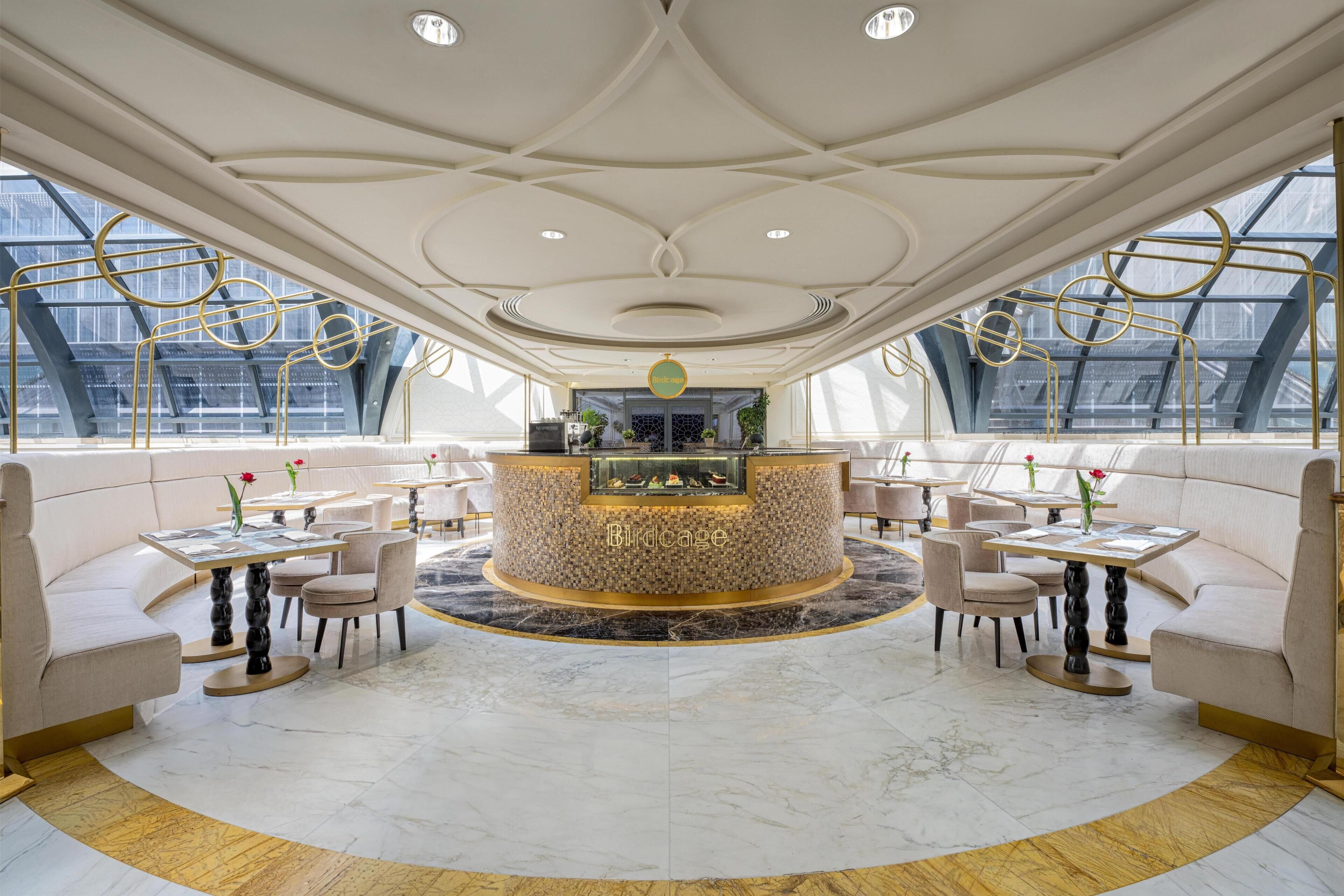 A luxurious interior with a central bar, seating arrangements, and large windows.