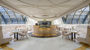 A luxurious interior with a central bar, seating arrangements, and large windows.