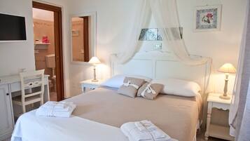 A neatly arranged bedroom with a large bed, two bedside tables with lamps, a wardrobe, and a mirror.