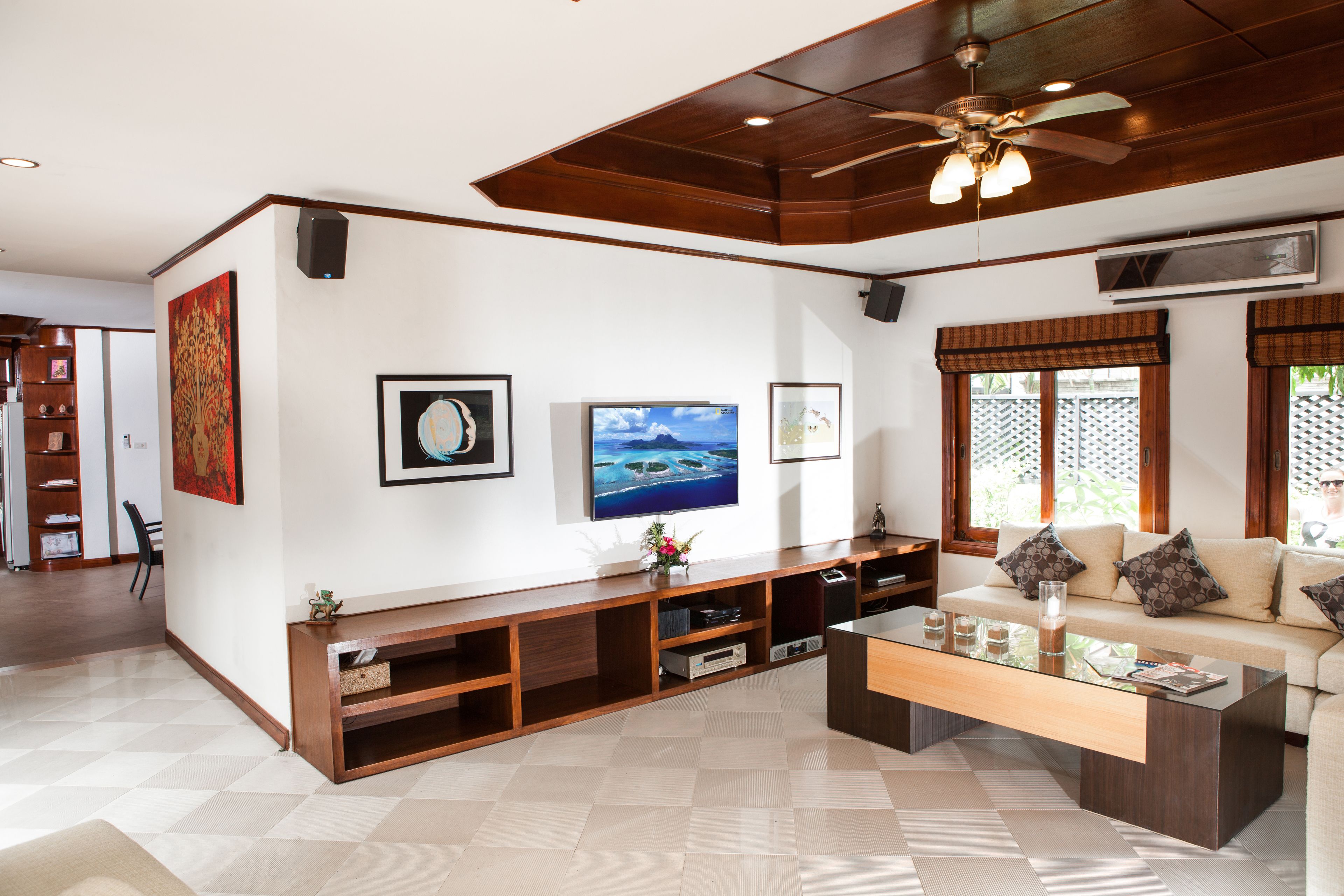 A modern living room with a sofa, coffee table, TV, and entertainment unit.
