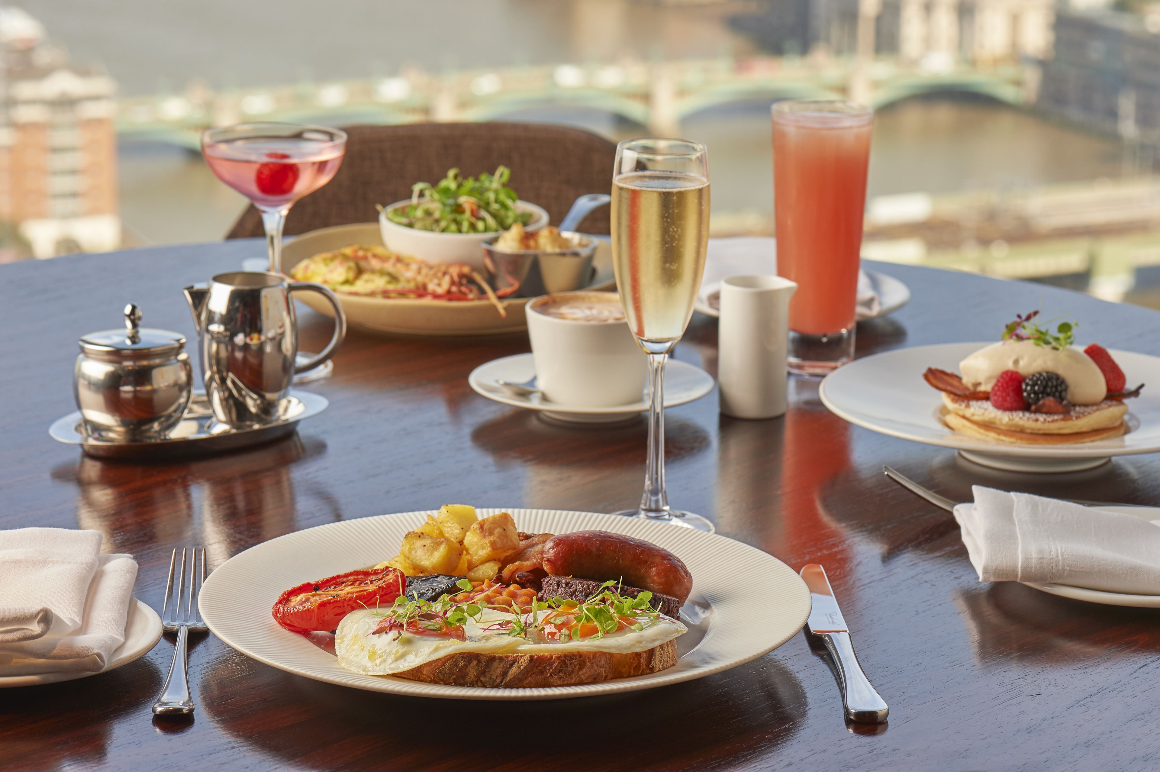 A dining table with a variety of dishes, drinks, and cutlery.