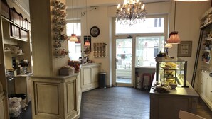 A cozy kitchen with wooden cabinets, a chandelier, and a view through a glass door. - La Terrazza di Arturo (Turin)