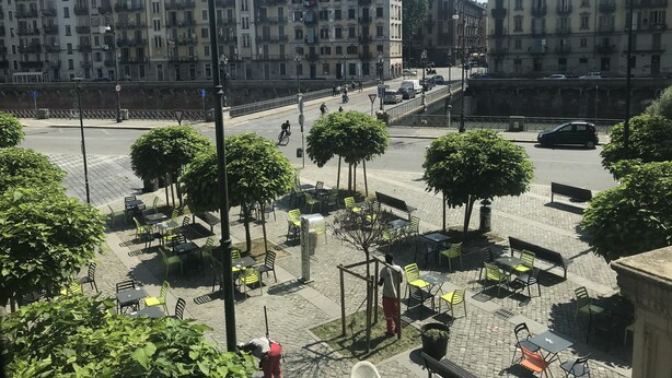 A city square with outdoor seating, a pedestrian bridge, and historic buildings in the background. - La Terrazza di Arturo (Turin)