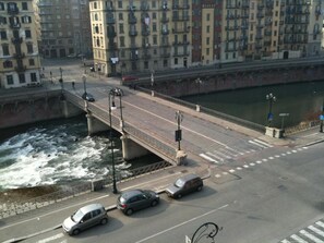 A bridge over a river with cars on the road and buildings in the background. - La Casa di Arturo (Turin)