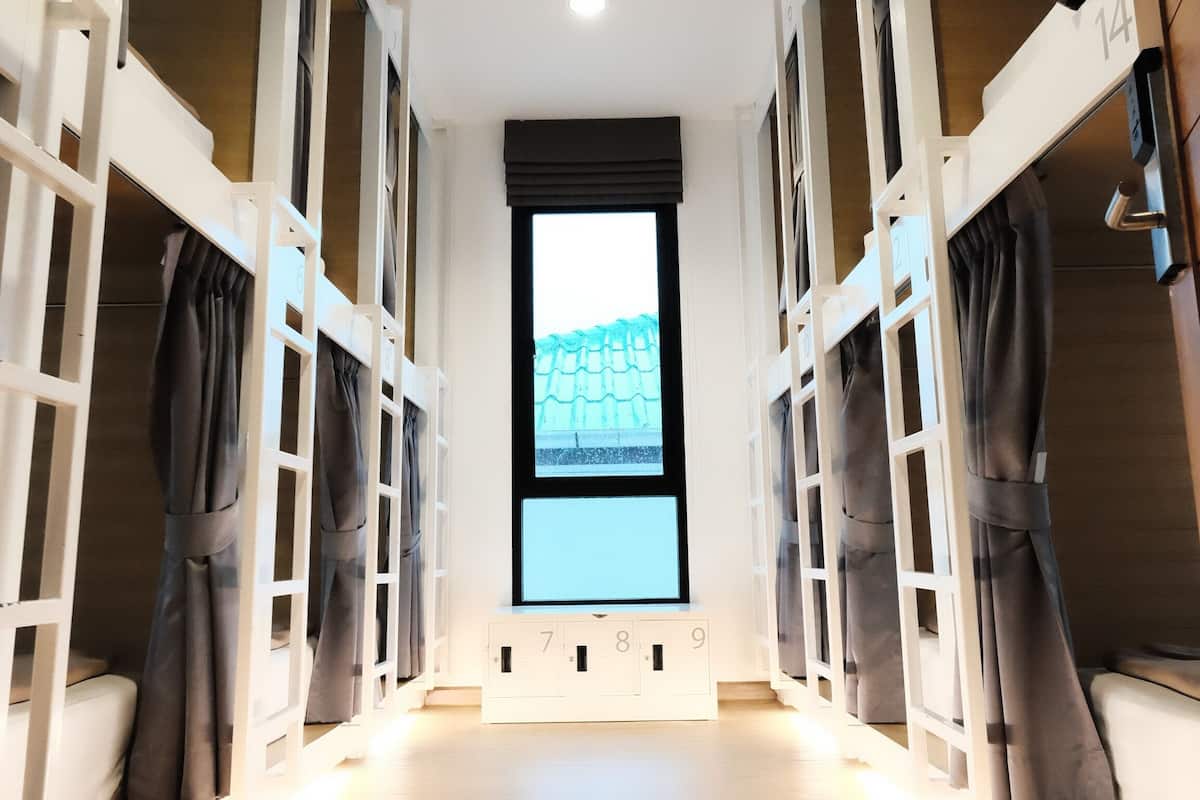 Ein Zimmer mit Etagenbetten, einem großen Fenster und einer Klimaanlage.