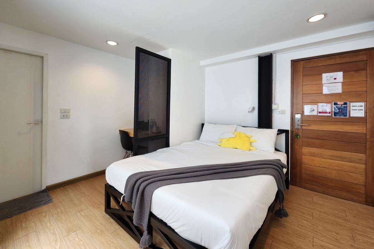 Ein ordentlich eingerichtetes Schlafzimmer mit Bett, Schreibtisch und Kleiderschrank.