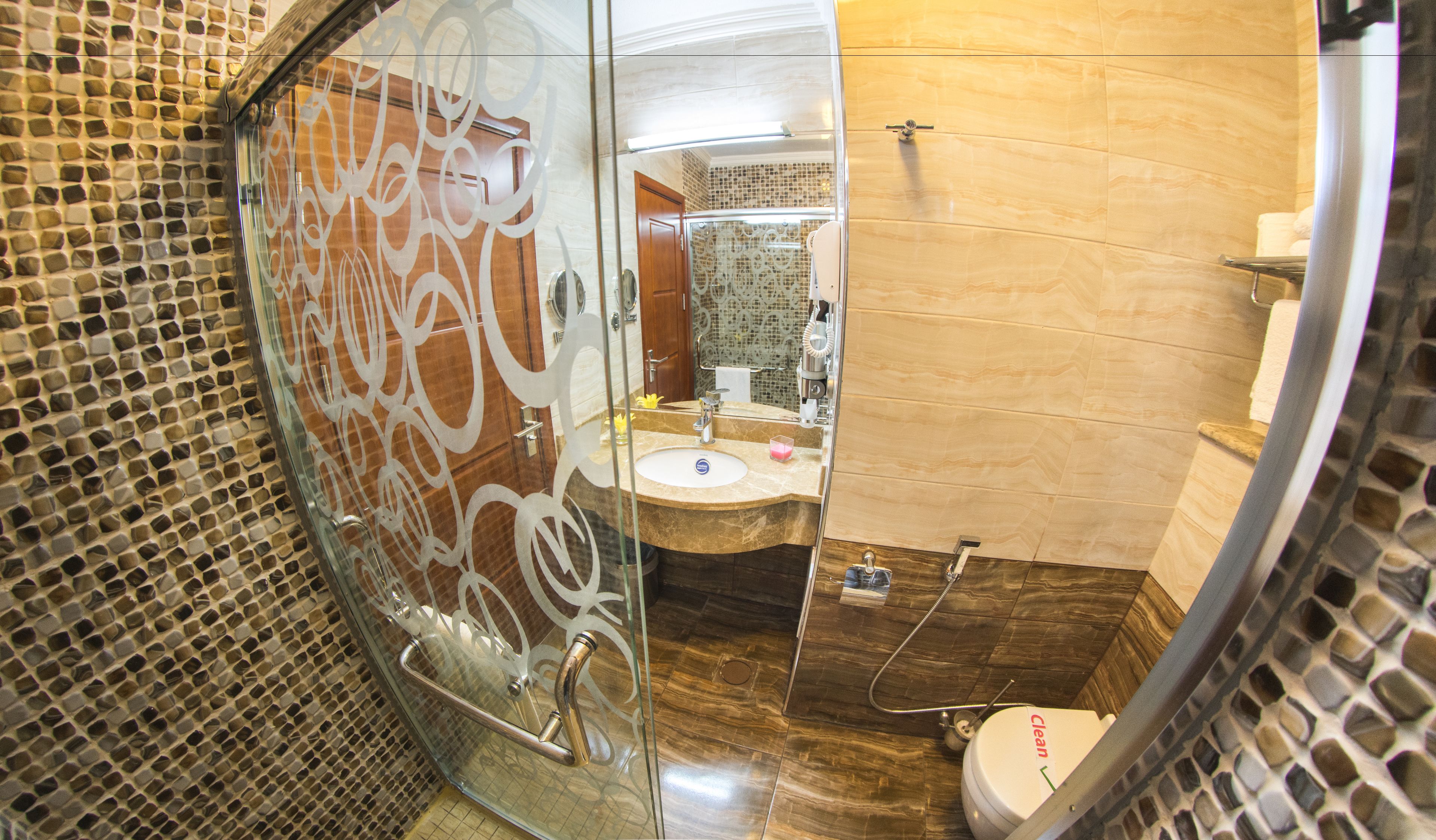 Une salle de bain avec une douche à parois de verre, un lavabo avec un miroir et des toilettes.