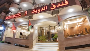 The exterior of Dweik Hotel with a prominent entrance, multiple balconies, and a sign indicating the hotel's name and location. - Dweik Hotel 3 (Aqaba)