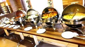 A buffet table with multiple serving dishes containing various food items. - Dr. Rajkumar International Hotel (Bengaluru)
