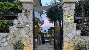 A stone entrance gate with a sign reading "Casa Scrocco" and a website address.