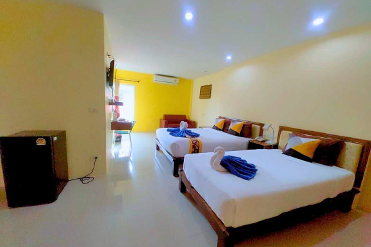 A hotel room with two beds, a desk, and a television.
