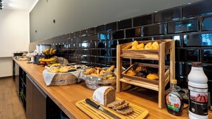 A breakfast buffet with various breads, pastries, and condiments. - Hotel Bergheim an der Erft (Bergheim)