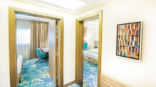 A hotel room with a bed, a desk, a chair, and a large mirror.