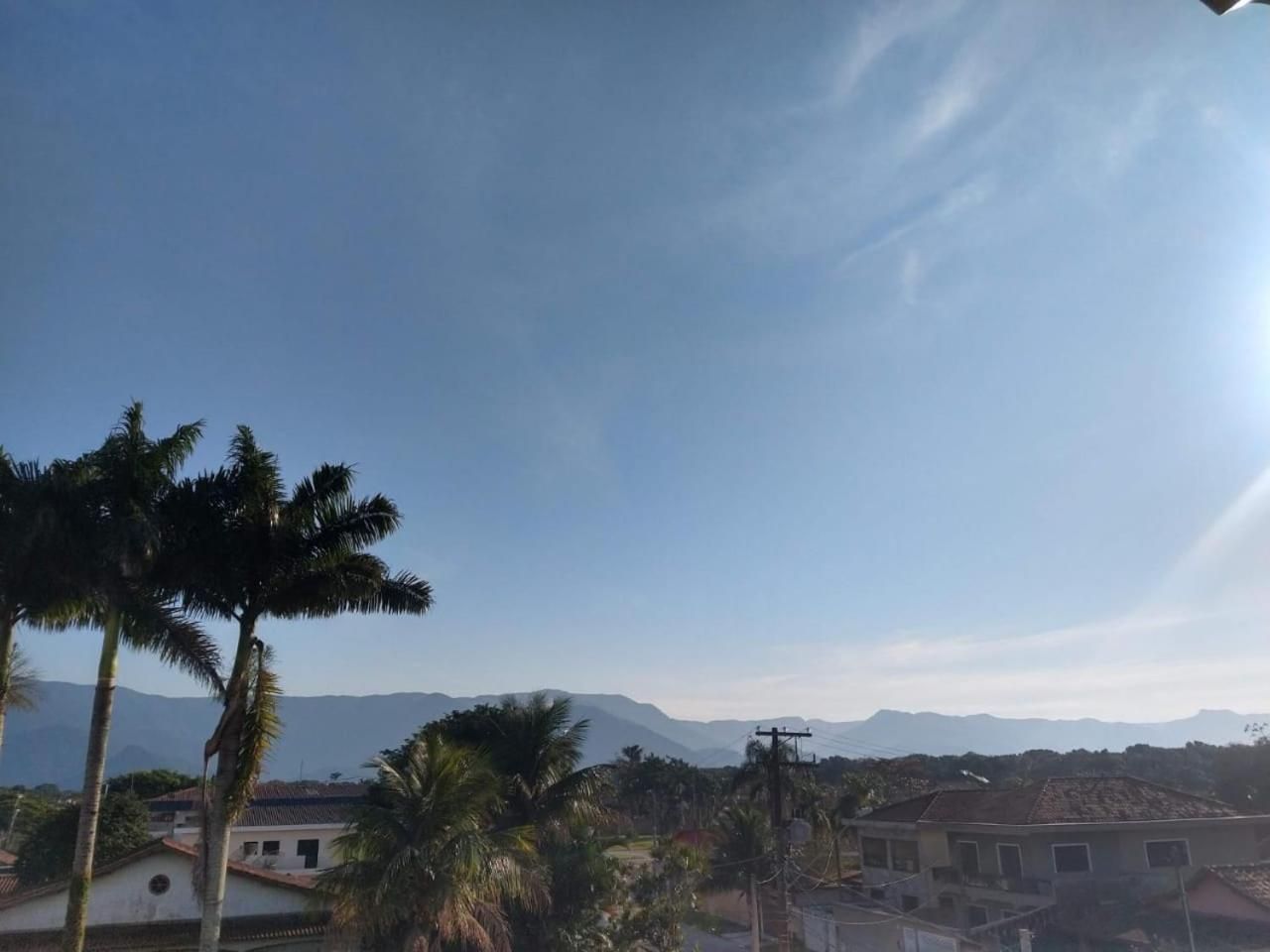 Zona residencial con casas, palmeras y montañas lejanas bajo un cielo despejado.
