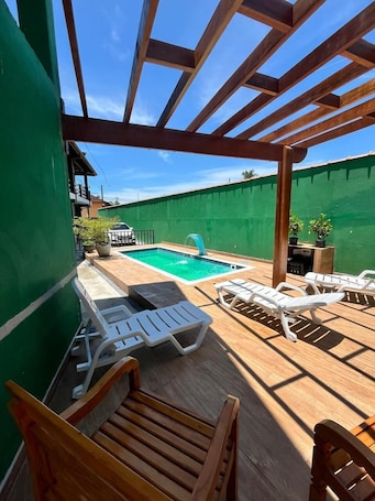 Una piscina al aire libre, sillones reclinables de piscina