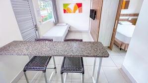 A compact room with a bed, a small table, and a bench. - Diroma Lacqua I - Direto com o Grupo Diroma - Acesso ao Acqua Park com Café da Manhã (Caldas Novas)