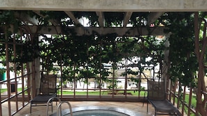 A covered outdoor swimming pool with a circular shape, surrounded by stone tiles and metal railings. - Diroma Lacqua I - Direto com o Grupo Diroma - Acesso ao Acqua Park com Café da Manhã (Caldas Novas)