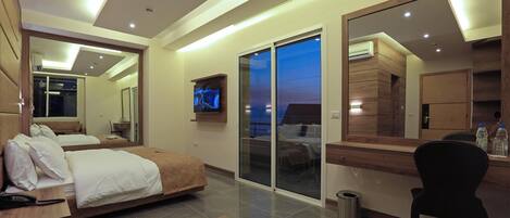 Una habitación de hotel moderna con una cama grande, un escritorio, una silla y un televisor.