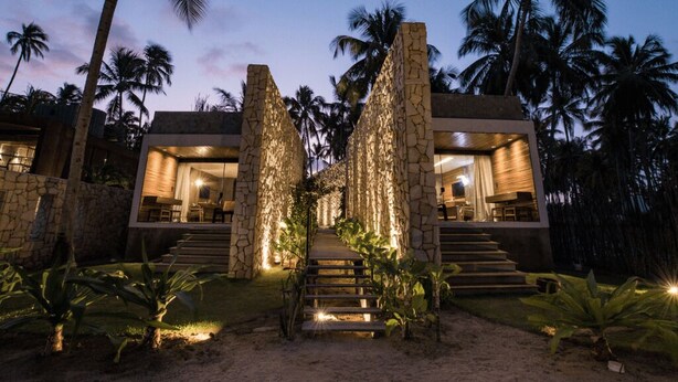 A modern villa with a stone facade, a central staircase, and a well-lit interior. - Pedras Do Patacho Hotel Boutique Experience (Porto de Pedras)