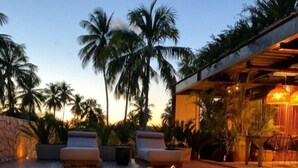 A serene pool area with lounge chairs and a stone wall, surrounded by palm trees. - Pedras Do Patacho Hotel Boutique Experience (Porto de Pedras)