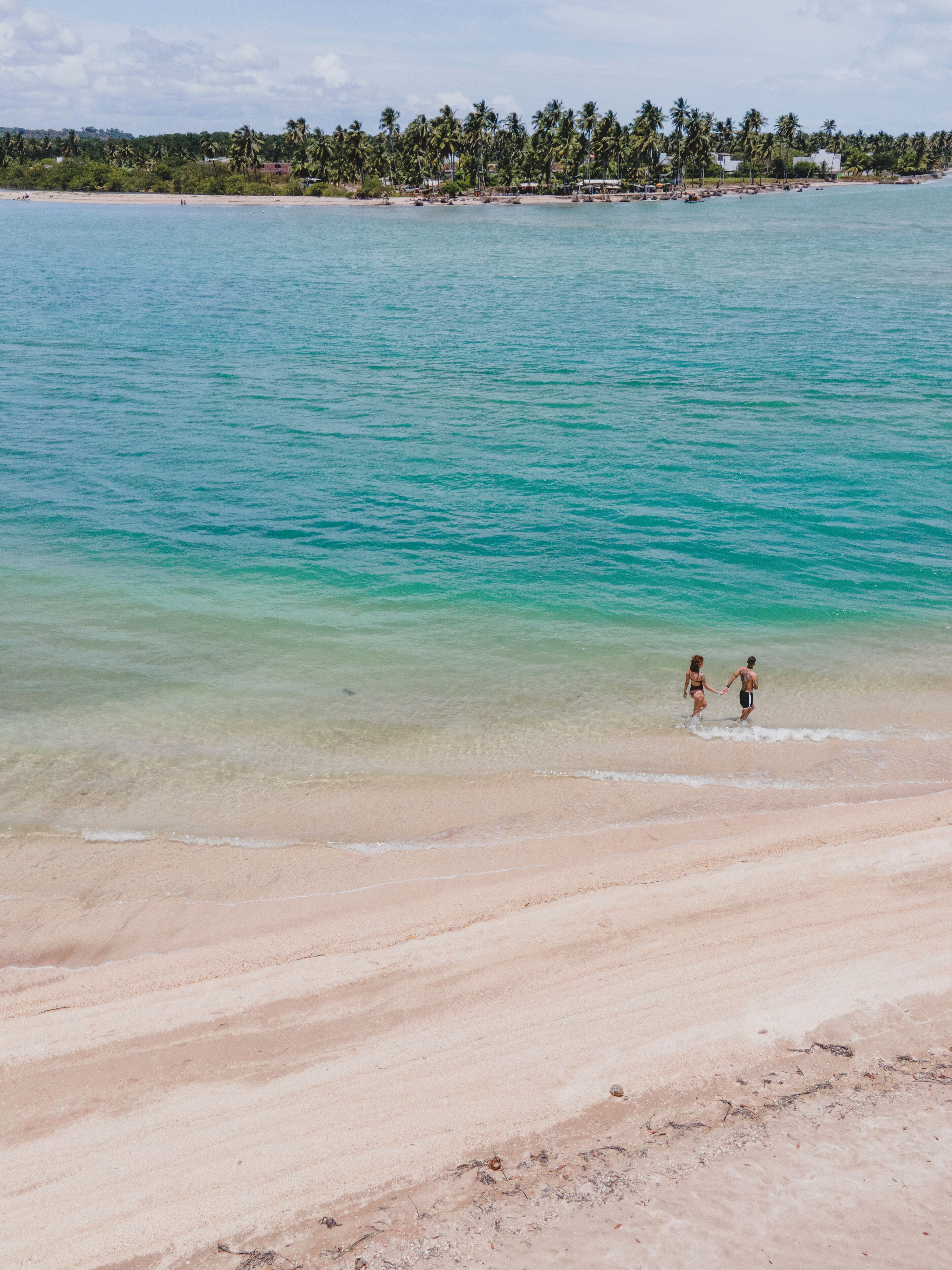 Een strand met helder turquoise water en een zandstrand.