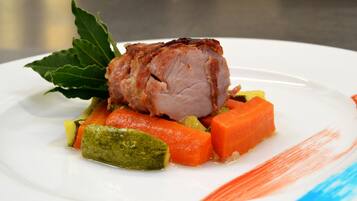 Un plato con carne, zanahorias y un vegetal verde.