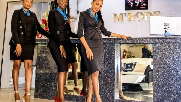 A reception area with a marble counter, a Samsung monitor, and a sign that reads "MRODE". - Hotel M'Rode (Lomé)